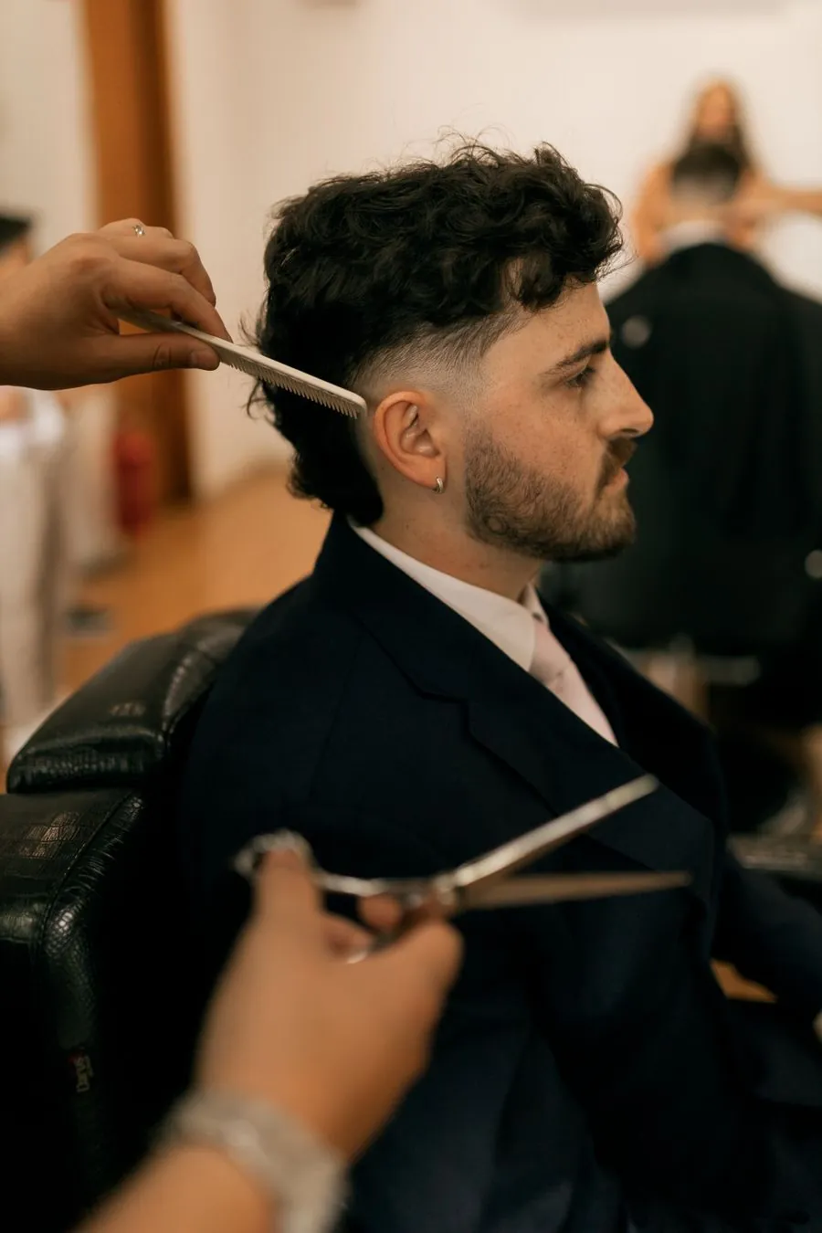 Client barbu de profil pendant une coupe aux ciseaux