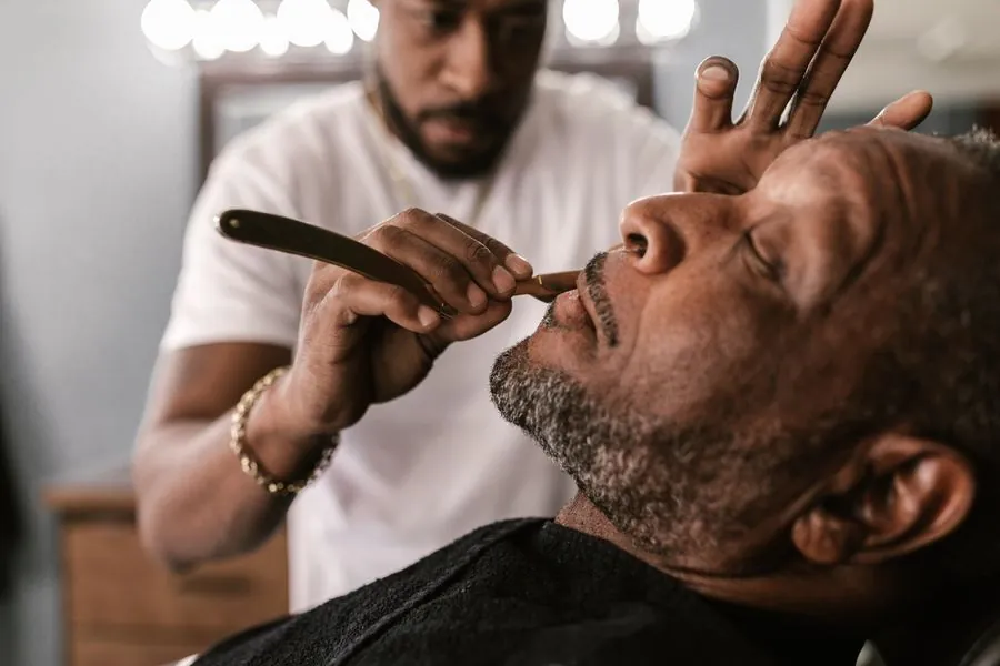 Rasage au rasoir droit, client allongé dans le fauteuil