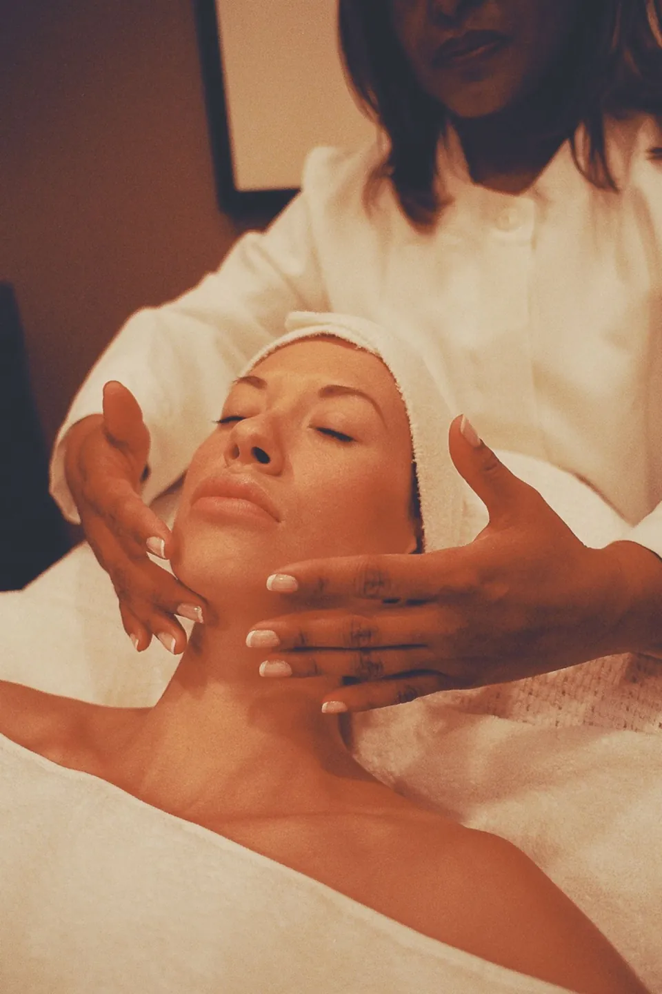 Massage du visage pendant un soin, dans une lumière chaude
